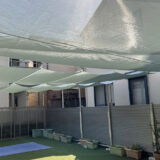 保育園の園庭に簡易式日除けタープとらくらく開閉の日除けテント新設